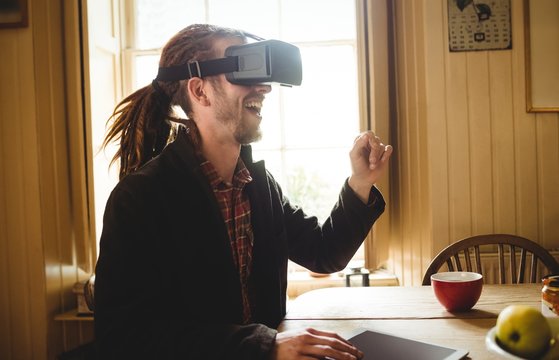 Happy young man using virtual reality simulator