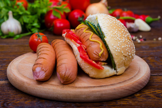 Grilled Hot Dog With Sausage On A Background Of Vegetables