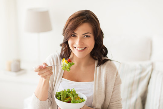 Smiling Young Woman Eating Salad At Home