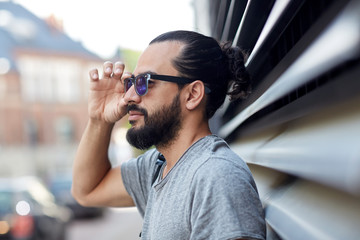 happy man with beard and sunglasses on city street