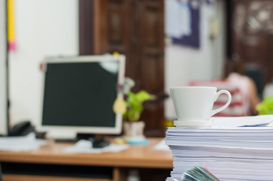 Coffee cup put on document group in work office,soft focus.