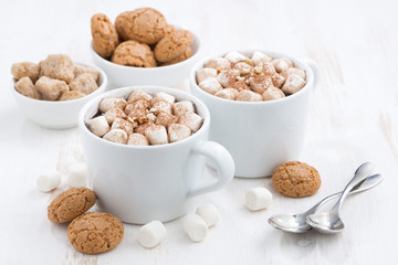 two cups of flavored cocoa with marshmallow on white table