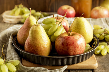 Plate with pears and apples and grapes on wooden.Thanksgiving dinner.