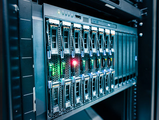 Computer Server mount on rack in data center room with red lighting alarm..