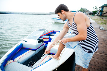 Young handsome man preparing boat to start a journey