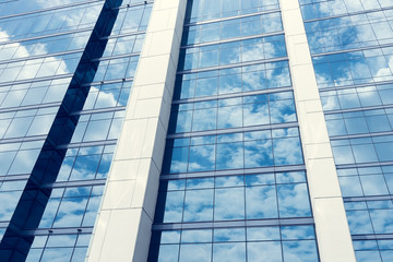Glass of modern tower with sky reflection for business backgroun