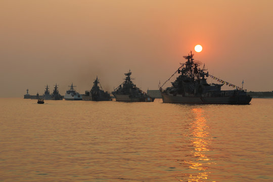 silhouette of military ships on sunset