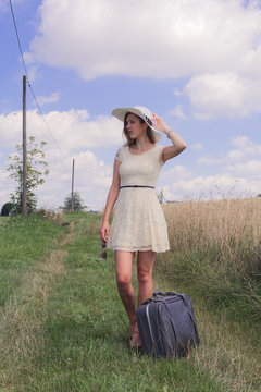 woman with suitcase at the field edge