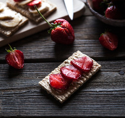 Fruity toast on wooden background. Strawberries, bread, butter and cheese.Vintage style