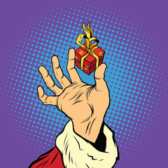 Hand of Santa Claus and a small gift