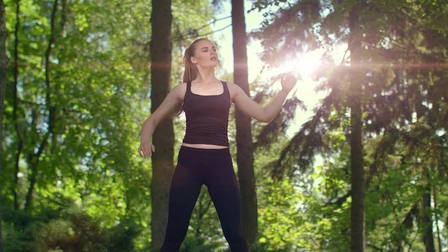 Woman stretching in park at evening. Young female runner warm up outdoor at sunset. Fitness girl doing stretching exercise. Wellness concept. Slim woman in sport clothes workout outdoor at spring
