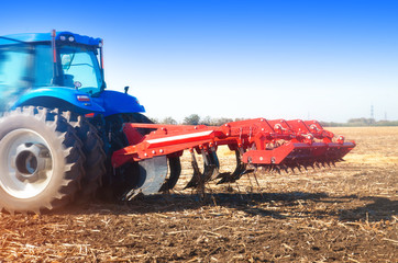 Tractor in a field, autumn sunny day
