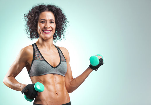 Smiling fit woman lifting weights