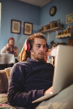 Man using laptop while listening music at home