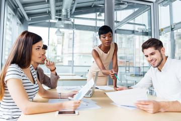 Fototapeta premium Group of colleagues discussing ideas and planning work in office