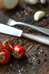 Rispentomaten Knoblauch Zwiebel auf Holzbrett