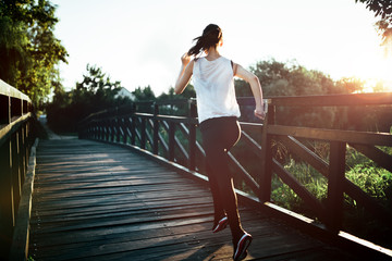 Beautiful jogger crossing bridge