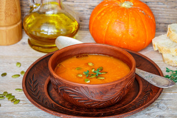 Pumpkin cream soup with thyme and pink pepper. Delicious healthy lunch
