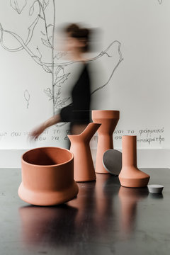 Silhouette of walking woman with ceramic objects on black table