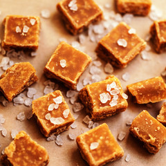Fototapeta na wymiar Salted caramel pieces and sea salt close up, top view