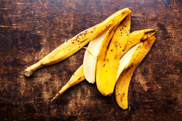 A branch of rotten ripe bananas peel  on vintage wooden backgrou