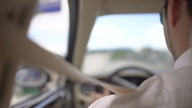 Business driver complying with safety rules, driving luxury car with seatbelt on