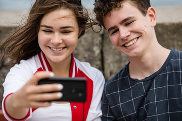 Young woman and man taking selfie photos