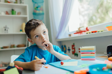 Back to school. Portrait of a thinking student doing his homework at home.