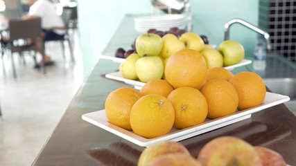 Fresh fruits on breakfast in a restaurant. Enjoying sweet oranges and apples on summer vacation. Healthy food concept