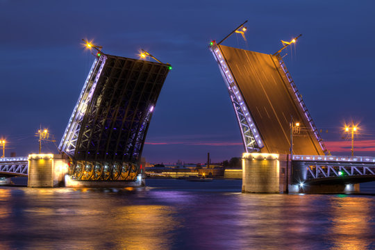 Night view on illumunated open Palace Bridge and Neva River, St. Petersburg, Russia.