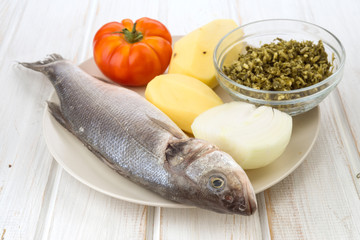 Raw sea bass ready to be roasted in white china