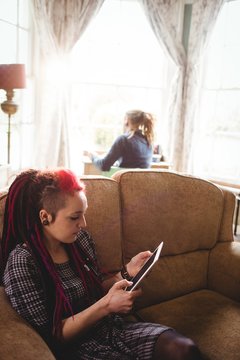 Hipster woman using digital tablet at home