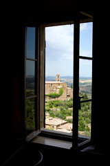 A view on the Tuscan old town and surrounding landscape from a window.
