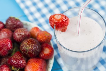 Strawberry milkshake near plate of berries