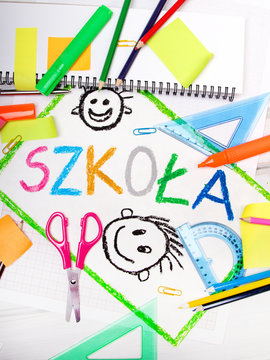 kolorowy napis "szkoła" otoczony szkolnymi przyborami. 