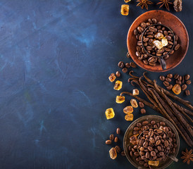 Coffee beans, chocolate drops, vanilla pods, cinnamon sticks, anise stars and brown sugar in a vintage silver cups on  dark textural wooden background. selective Focus