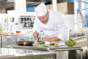 Chef prepares steak dish at gourmet restaurant kitchen