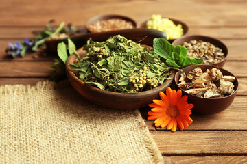Herb selection used in herbal medicine in bowls  on wooden table