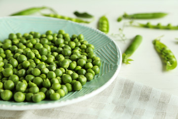 Fresh green peas in plate on napkin