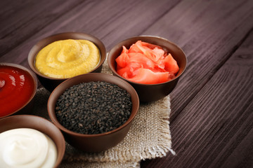 Fresh condiments and sauces on wooden background