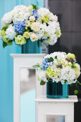 White bouquet made of peonies lies on the blue cloth