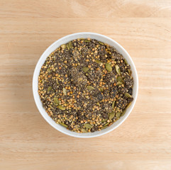 Chia cranberry and pumpkin seeds breakfast cereal in bowl on a wood table top.