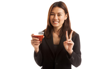 Asian woman show victory sign with tomato juice.