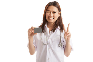 Asian young female doctor show victory sign with blank card.