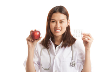 Young Asian female doctor with pills and apple.