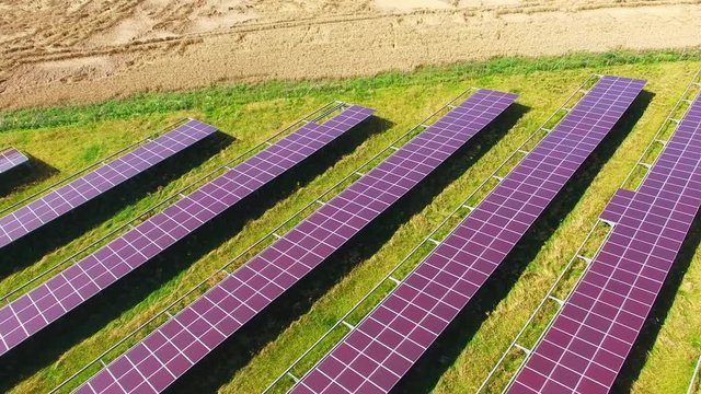 Camera flight over a solar power plant in agricultural landscape. Industrial background on renewable resources theme. Industry of power and fuel generation in European Union. 