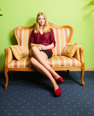 Pretty young woman on vintage sofa. Fashion.