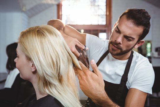 Female getting her hair trimmed with scissor