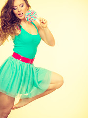 Woman charming girl with lollipop candy