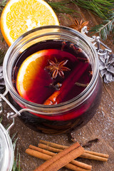 Christmas drink with orange fruit, anise, cinnamon and cloves on wooden table